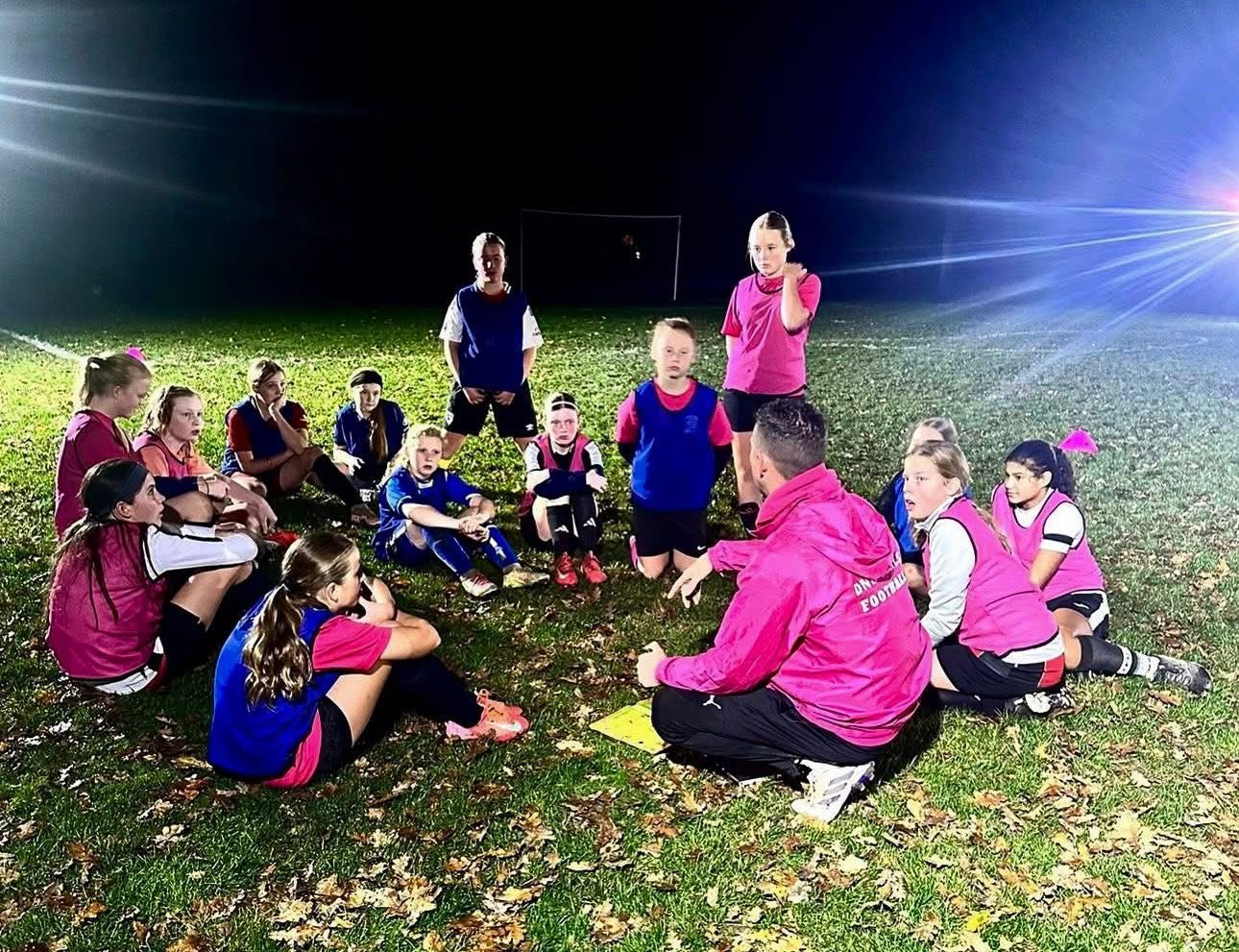 Dave coaching his players under the floodlights at night